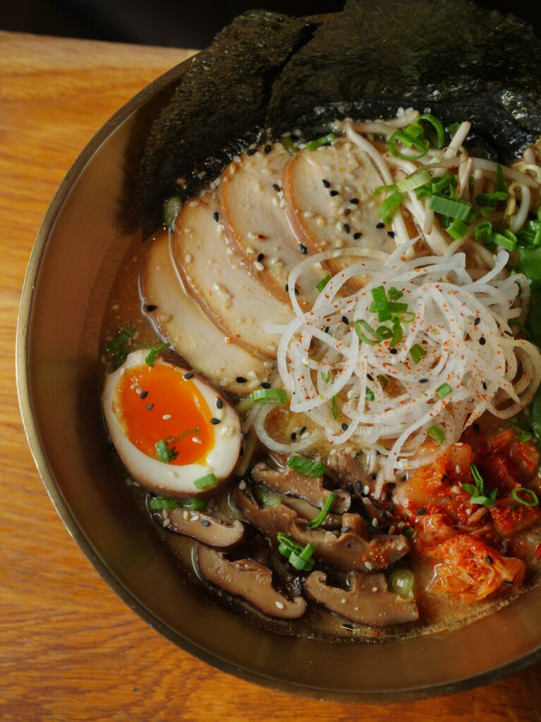 A flavorful ramen bowl with egg, mushrooms, and seaweed in a cozy setting.